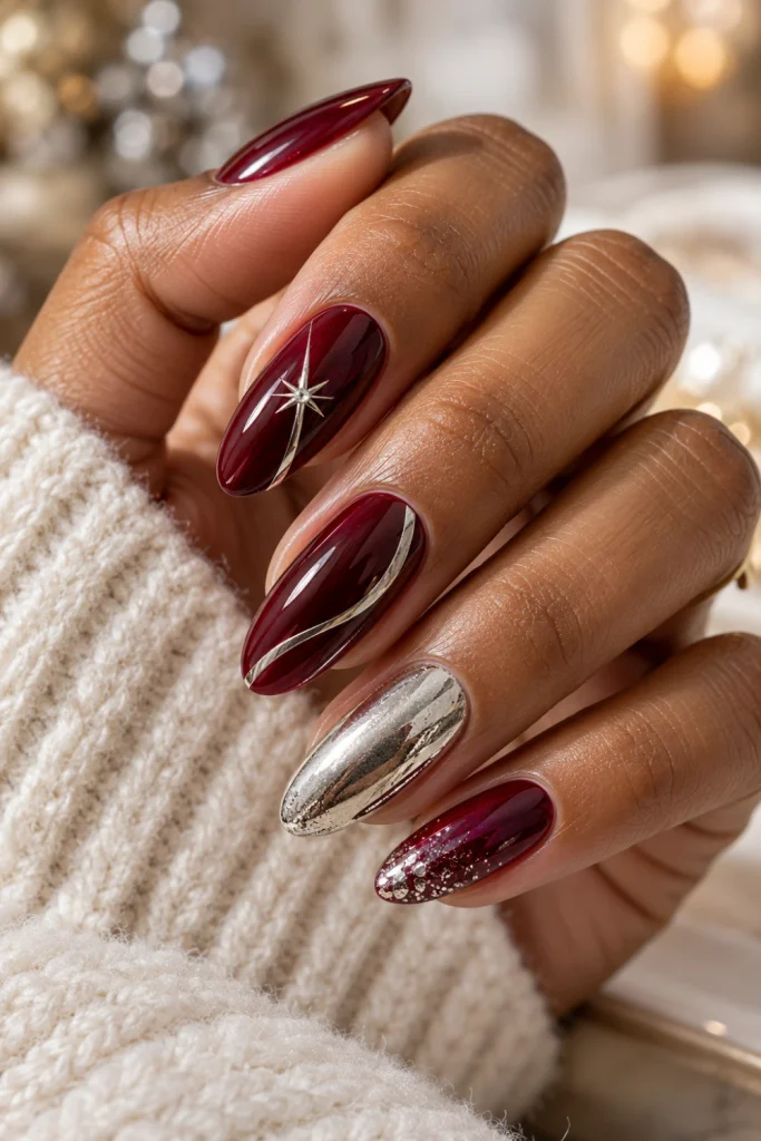 Burgundy Christmas nail polish with deep wine-red glossy nails, delicate silver chrome accents and an elegant almond manicure.